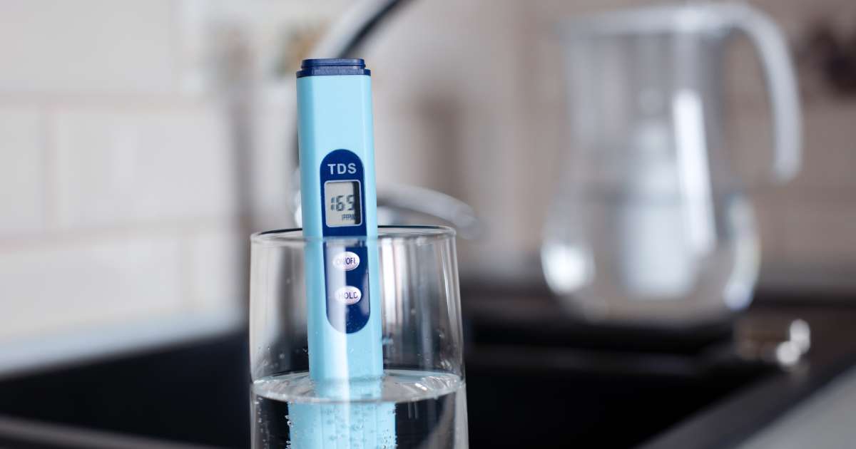 Kit test dureté de l'eau dans un verre dans une cuisine.